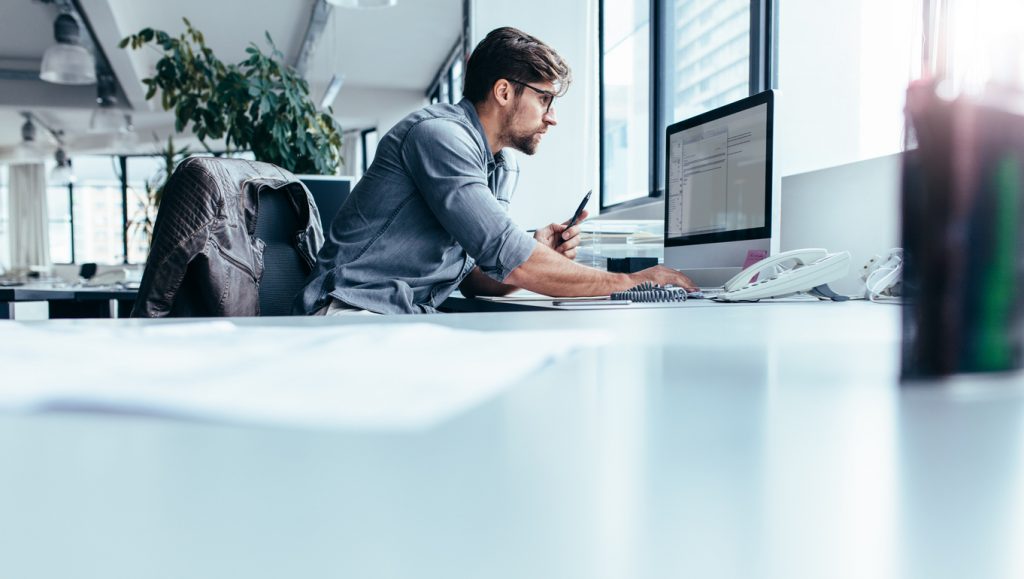 man-working-in-office-with-natural-light-coming-through-windows