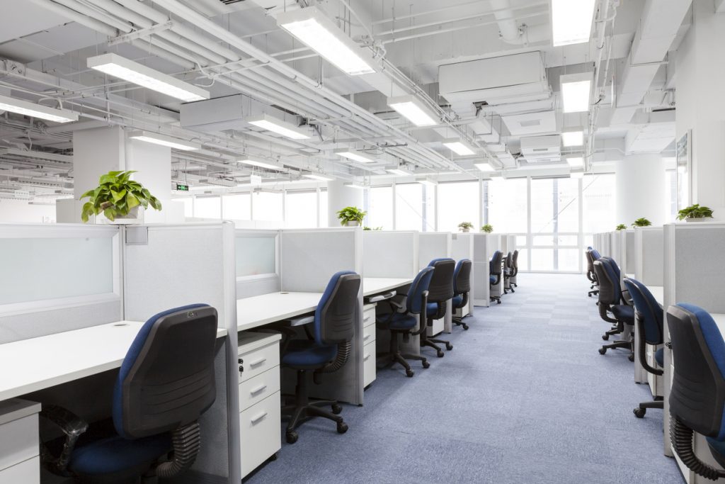 office-with-dividers-between-desks-and-bright-fluorescent-overhead-lighting