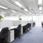 office-with-dividers-between-desks-and-bright-fluorescent-overhead-lighting