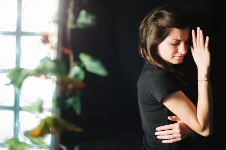 woman covering eyes from light due to photophobia